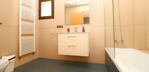 A modern bathroom with a toilet, a sink with a mirror above it, a shower area, and a radiator on the wall. - Son Vigili, Free Wi-Fi, private pool, Air conditioning (Campos)
