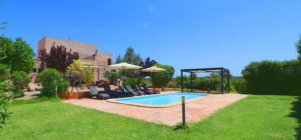 A backyard with a swimming pool, lounge chairs, and umbrellas. - Son Vigili, Free Wi-Fi, private pool, Air conditioning (Campos)