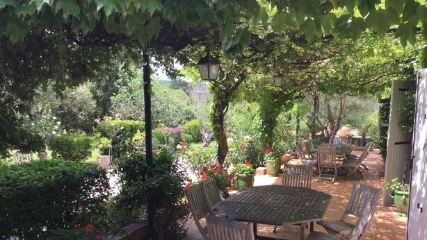 An outdoor patio with a round table and chairs, surrounded by potted plants and trees. - Family house between Toulouse and Carcassonne (Saint-Paulet)