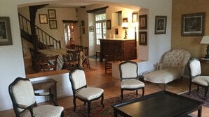 A living room with a sofa, armchairs, a coffee table, and a staircase leading to another room. - Family house between Toulouse and Carcassonne (Saint-Paulet)