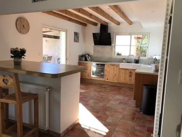A kitchen with wooden cabinets, a central island, and a large window.