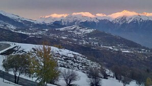 Eine Berglandschaft mit schneebedeckten Gipfeln und einem Tal darunter.