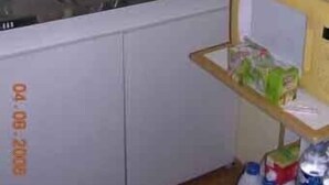 Eine Küche mit Spüle, einer kleinen Holztrennwand mit Gegenständen und einem Datum an der Wand.