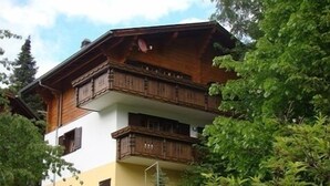 Een gebouw met twee verdiepingen, houten balkons en een stenen fundering.