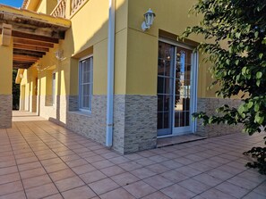 A building with a tiled patio, stone accents, and a large window.