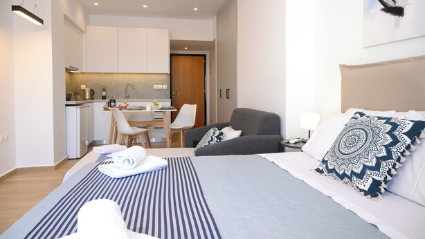Une chambre d’hôtel moderne équipée d’un lit, d’un bureau et d’une kitchenette.