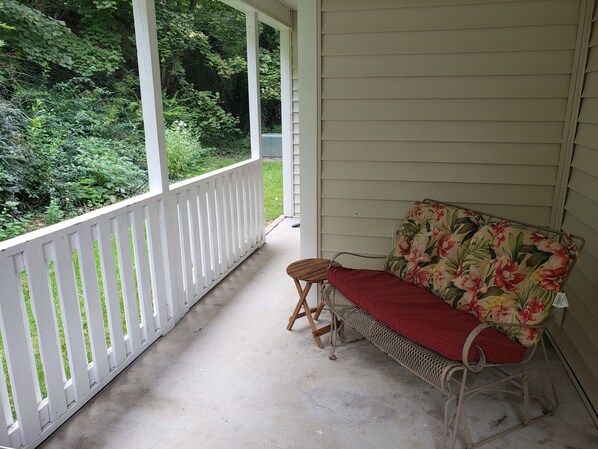 A porch with a wooden bench and a floral cushion. - Updated, 2 Bedroom Condo - Sleep 6 off of Price's Fork - 2 Night Minimum (Blacksburg)