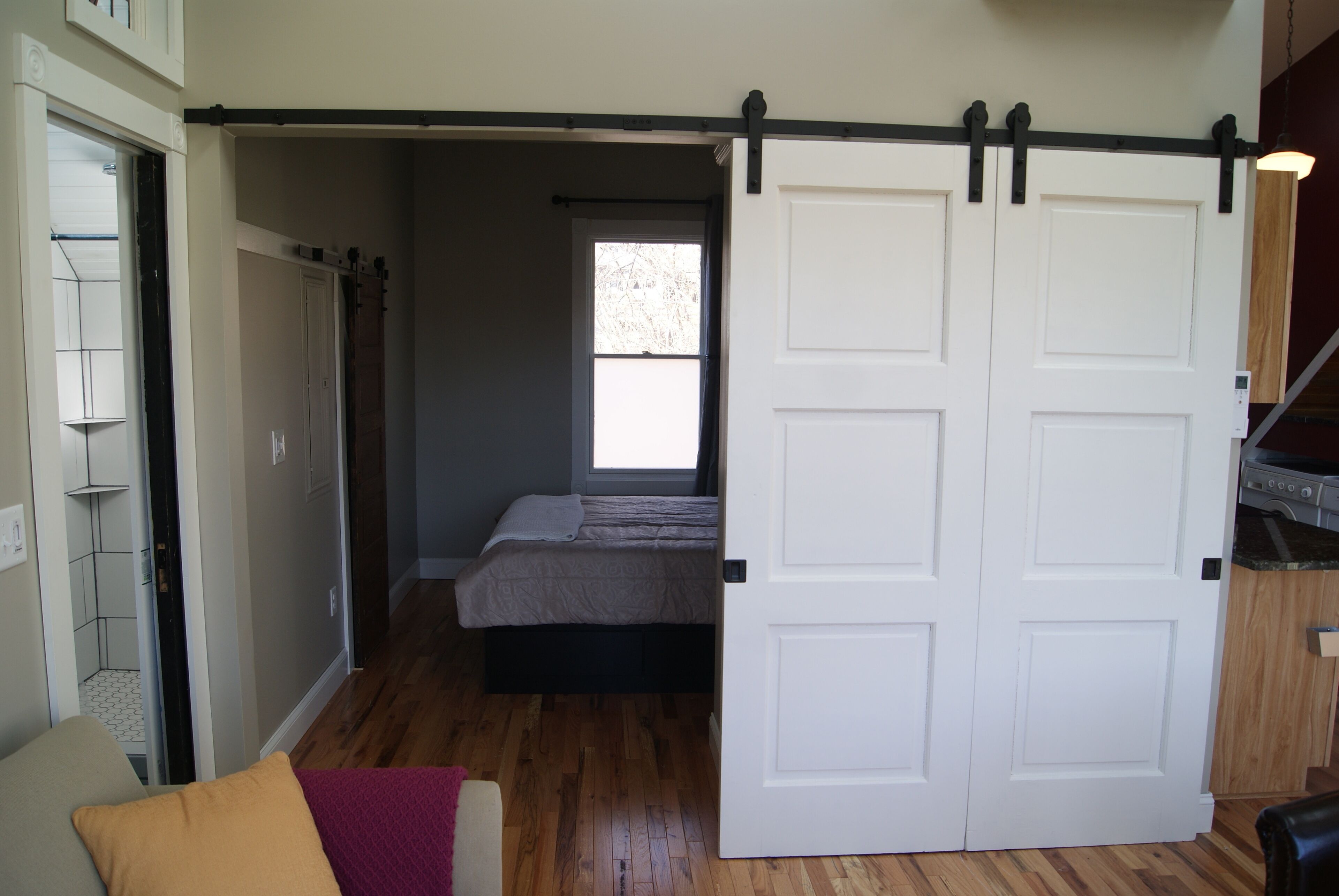 Une chambre avec une porte coulissante, un lit et une fenêtre.