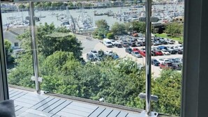 A balcony with a view of a marina and parking lot. - The Loft: Amazing views, parking & fantastic location! (Kingswear)
