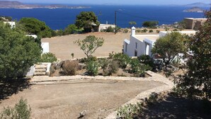 A coastal property with white buildings, a clear view of the sea, and a dry, rocky landscape. - Traditional villa in Hora with sea view to the Aegean  (ΠΑΤΜΟΣ)