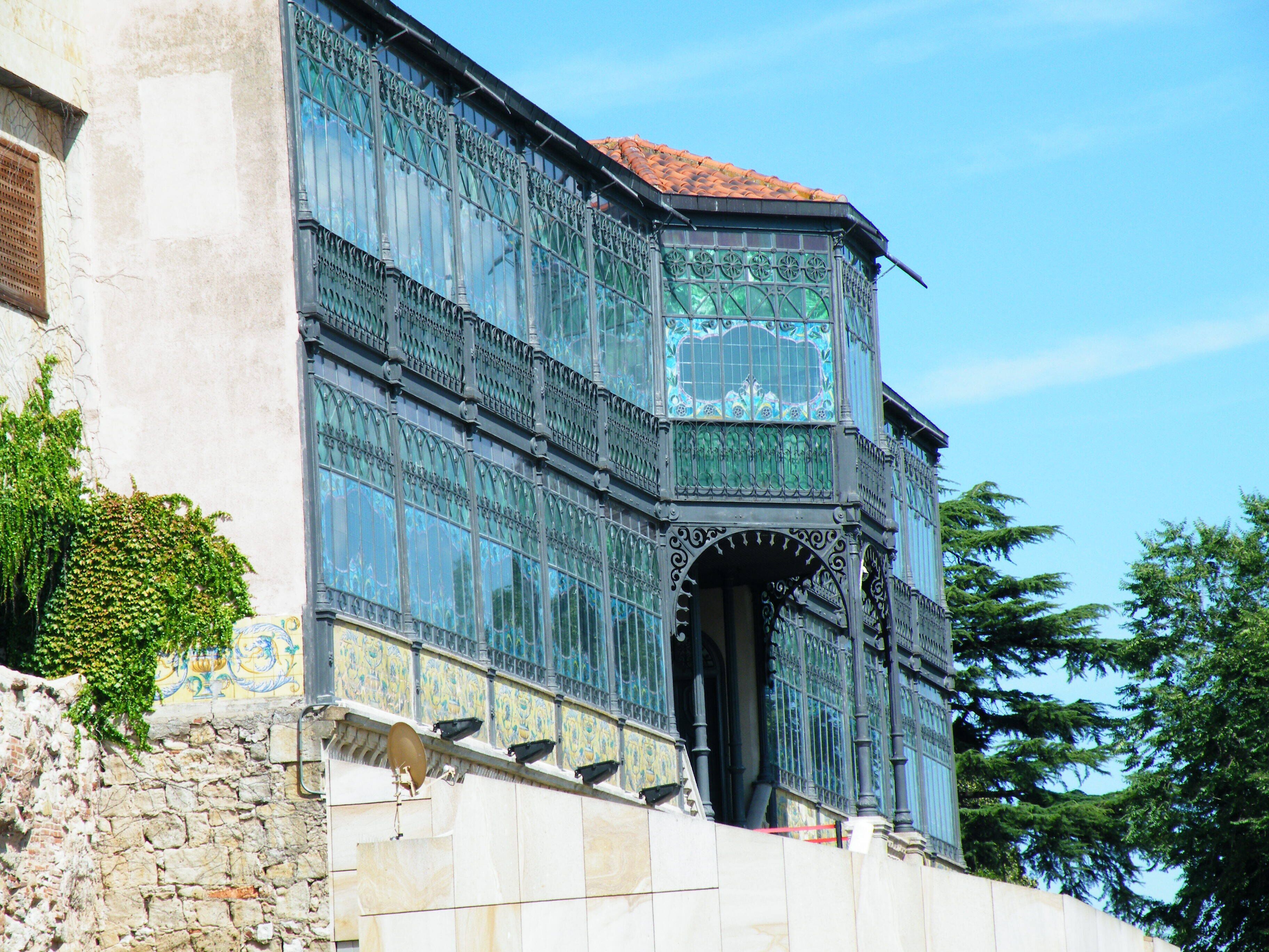 A historic building with ornate ironwork and large windows.