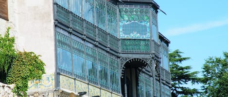 A historic building with ornate ironwork and large windows.