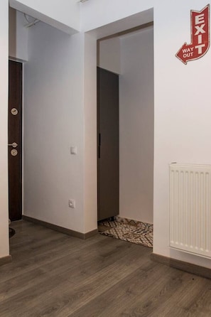 Ein Korridor mit einer Tür links und einem Hinweisschild für den Ausgang rechts.
