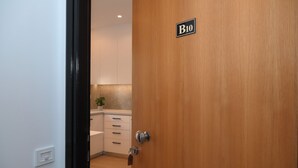 A wooden door with a keyhole and a lock, a wall-mounted light switch, and a small sign with the letter "B" and the number "10". - Economic Studio B10 (Iraklio)