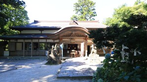 A traditional Japanese building with a stone pathway leading to a wooden entrance.
