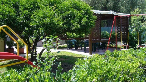 A garden area with a gazebo, a swing set, and a small table and chairs set up for outdoor dining. - Palinuro home 'Donna Antonia' (Palinuro)