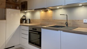 A modern kitchen with white cabinetry, a stainless steel sink, and a built-in oven. - COMPLETELY RENOVATED! NO PRICE INCREASE FOR 2026+2027 !!! BEACH CHAIR INCLUDED! (Binz)