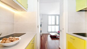 A modern kitchen with a white countertop, a bowl of almonds, and yellow cabinets.