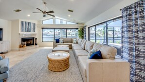 Ein großzügiges Wohnzimmer mit einer großen Couch, einem Couchtisch und einem Kamin.