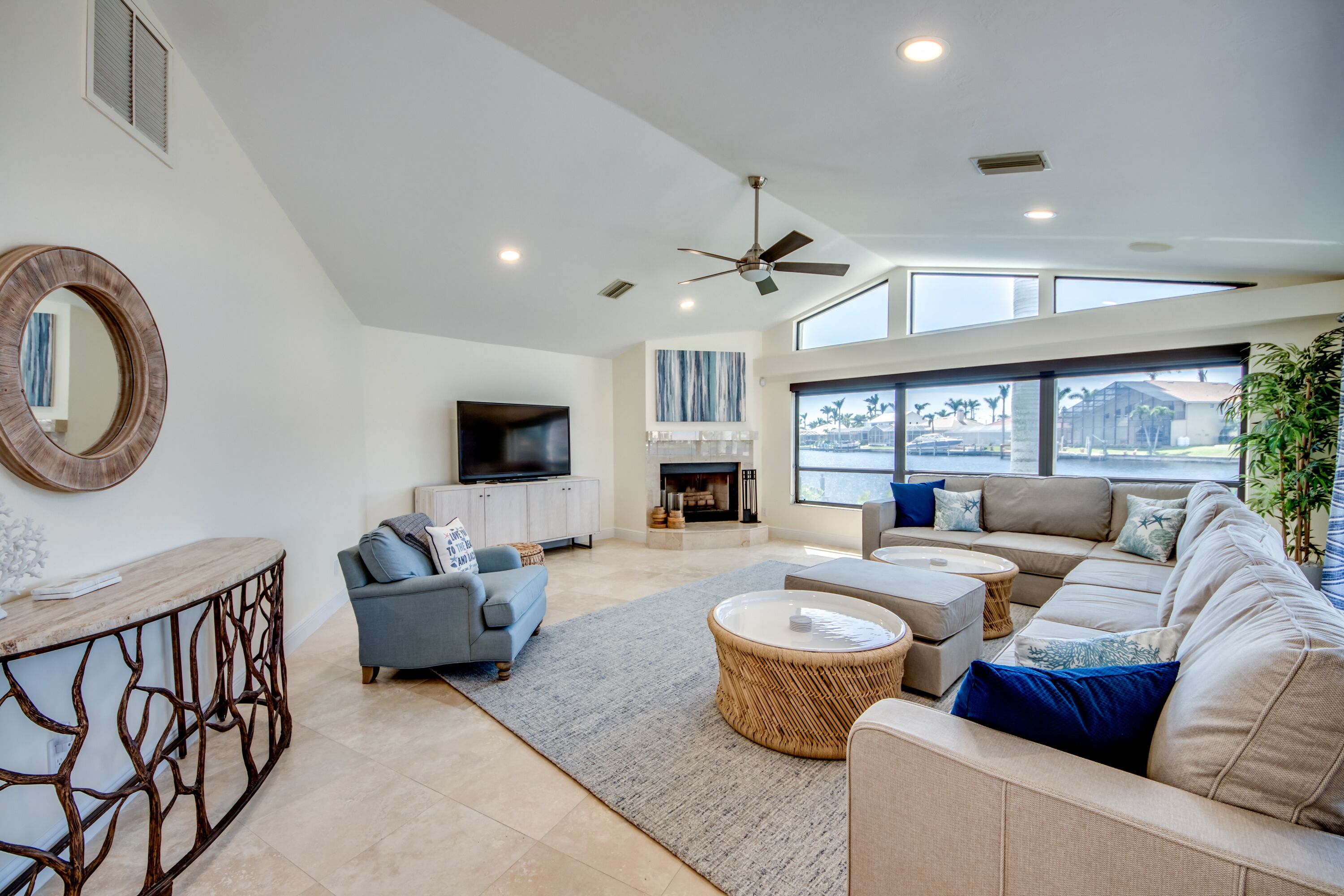 A spacious living room with a large sofa, a television, and a fireplace.