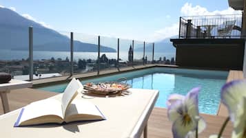 Relax by the pool with a mountain view, surrounded by a tranquil atmosphere and comfortable seating.