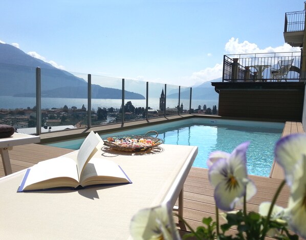 Relax by the pool with a mountain view, surrounded by a tranquil atmosphere and comfortable seating.