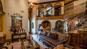 A grand lobby with a staircase, a sofa set, a coffee table, and a painting. - CASA VALENTINA-Beautiful Villa Estate (Whittier)