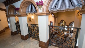 A grand hallway with ornate iron railings, arched ceilings, and a chandelier. - CASA VALENTINA-Beautiful Villa Estate (Whittier)