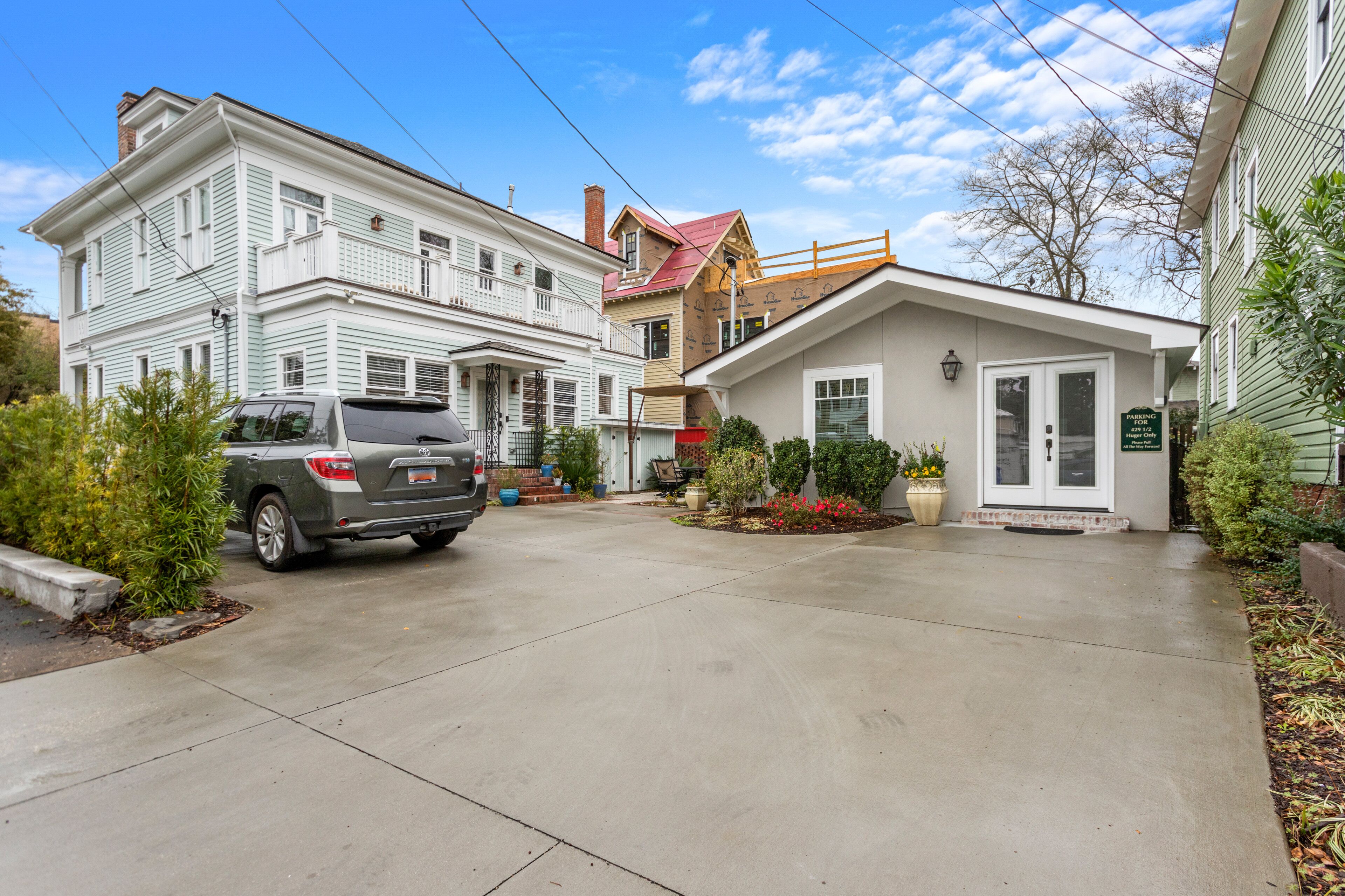 A residential street with a driveway leading to a house with a garage.
