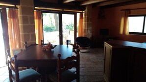 A dining area with a wooden table and chairs, a kitchen area with a counter and cabinets, and a view through a glass door to the outside. - Depandance Venera in Marsala with free wifi and air condition (Marsala)