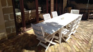 An outdoor patio with a white table and chairs, a brick floor, and a pergola overhead. - Depandance Venera in Marsala with free wifi and air condition (Marsala)