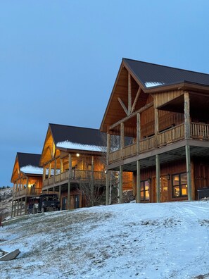 A multi-story wooden lodge with balconies and a covered driveway.