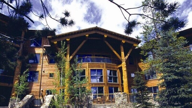 A log cabin with a stone foundation, wooden exterior, and a balcony with a railing. - Teton Club - 3 Bedroom/3 Bath, Ski in/Ski out, 2 free lift tickets (Teton Village)