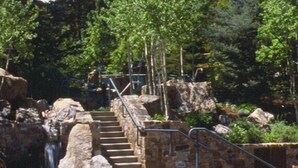 A hot spring area with a stone staircase leading up to a viewing platform, surrounded by large rocks and greenery. - Teton Club - 3 Bedroom/3 Bath, Ski in/Ski out, 2 free lift tickets (Teton Village)