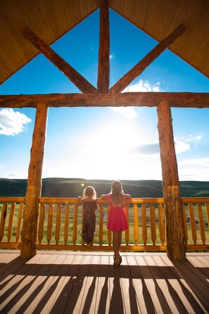 A wooden deck with a railing overlooking a landscape. - Cozy Two Bedroom Cabin on Private Montana Dude Ranch - Angler's Perch (Belt)