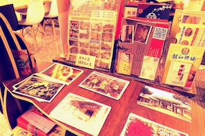 A table with brochures and postcards, some with Chinese text, and a QR code. - Lu-Kang Traveler Inns (Lukang)