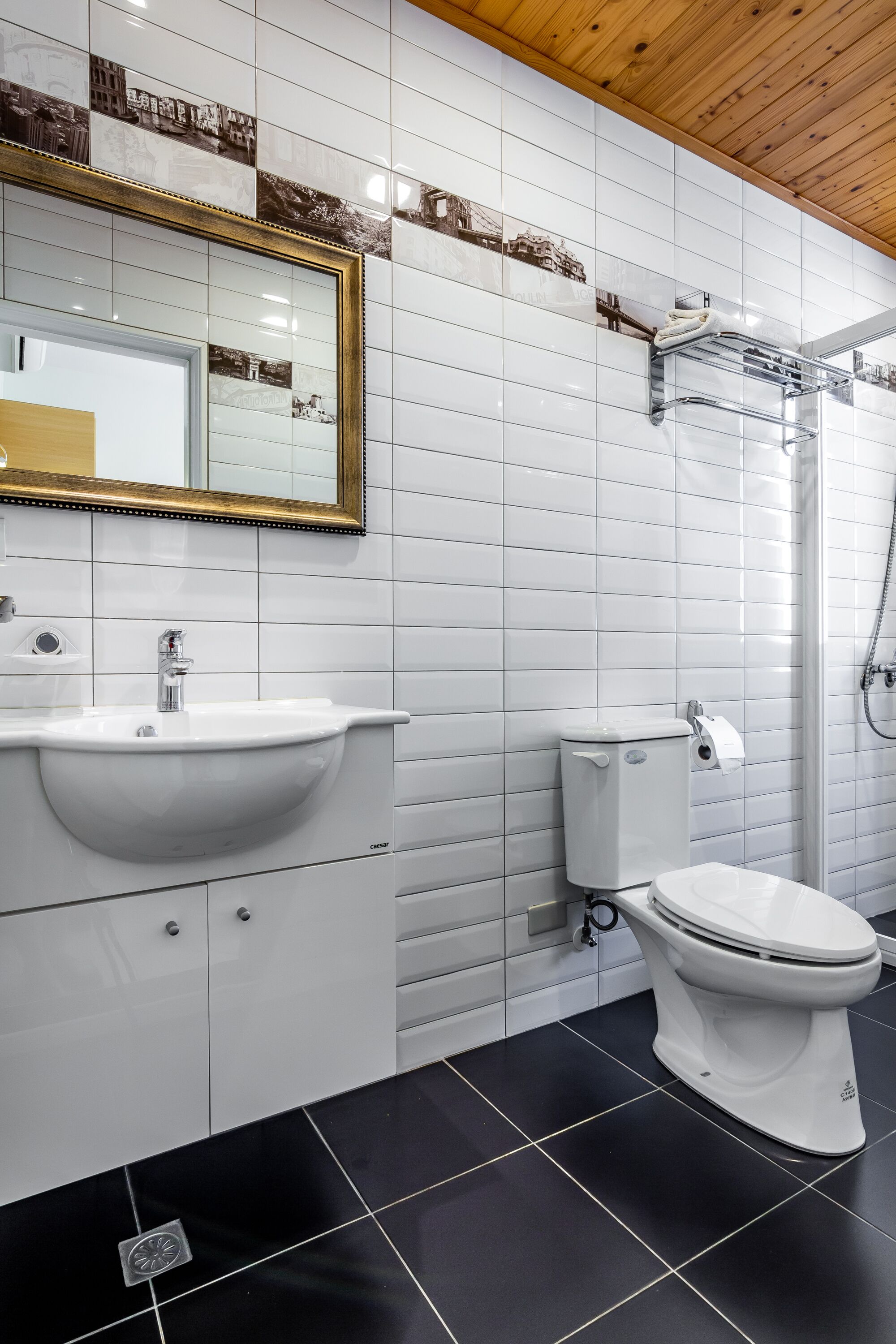 Une salle de bain moderne avec un lavabo, des toilettes et une douche, le tout de couleur blanche.