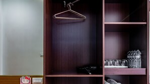Un armario de madera con varios estantes, una barra para colgar ropa y un mostrador con encimera de mármol.