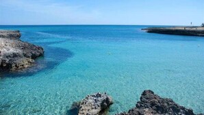A clear blue sea with rocky formations in the foreground. - Fittasi Studio in Ostuni (BR) (Ostuni)