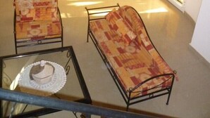 Un vaste espace de vie doté d’un haut plafond, d’une table à manger et de plusieurs chaises. On y trouve également une cheminée, une grande fenêtre et un escalier menant à l’étage supérieur.