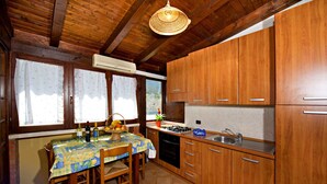 Una cocina con armarios de madera, salpicadero de azulejos, estufa a gas y un lavabo.
