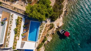 A modern villa with a rooftop pool, a boat, and a scenic coastal view. - Beachfront Villa Eleganza with Pool (Marina)