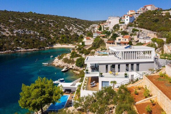 Une villa située sur la côte, dotée d’une piscine, d’une terrasse et offrant une vue sur la mer.