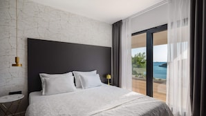 A bedroom with a large bed, a view of the sea, and a modern design. - Beachfront Villa Eleganza with Pool (Marina)