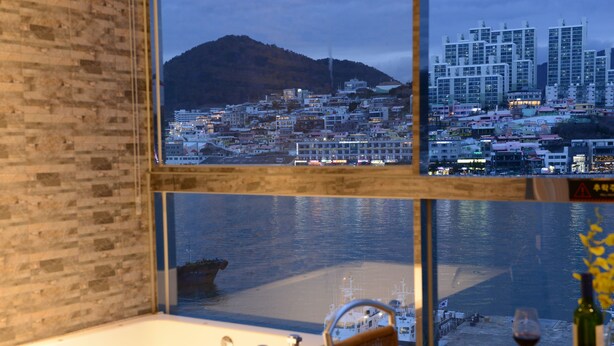 Una habitación con un ventanal grande que da a vistas de la ciudad y al agua.