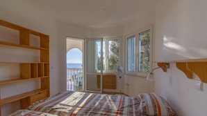 A bedroom with a bed, wooden shelves, a window, and a view of the sea. - Beach Apartment 1: private bathing area, sandy beach, WiFi, ideal for families (Novalja)