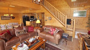 A log cabin interior with two brown leather sofas, a wooden coffee table, a staircase, and a ceiling fan. - Unique 7th Floor Penthouse. Views. Hot Tub Balcony (Frisco)