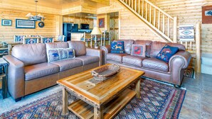 A log cabin interior with two leather sofas, a wooden coffee table, and a staircase. - Unique 7th Floor Penthouse. Views. Hot Tub Balcony (Frisco)