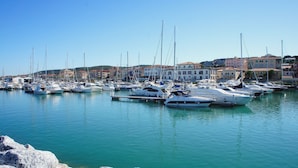 A marina with numerous boats docked, surrounded by buildings with Mediterranean architecture. - Farmhouse Pescinone - Poppy, country and sea (Banditelle)