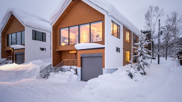 A modern two-story house with large windows, a wooden facade, and a snow-covered roof. - Koa Niseko (Niseko)
